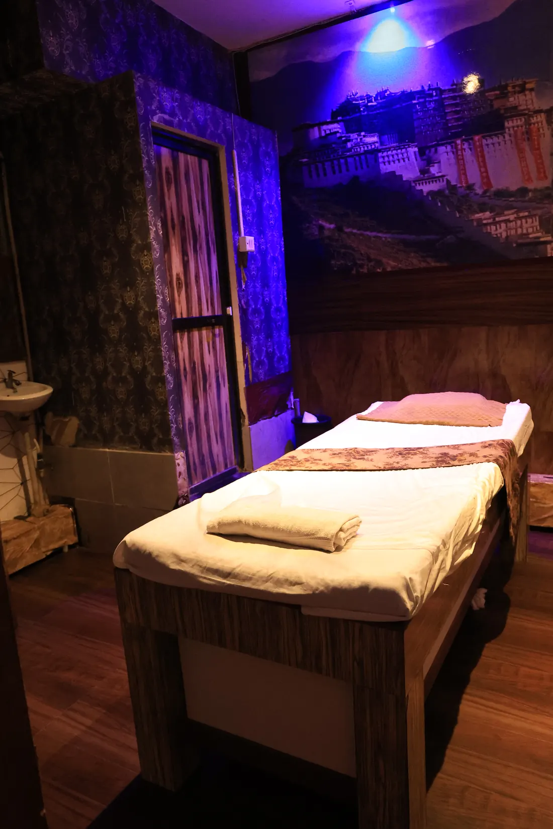 Massage table beside a mural wall at Deep Spa